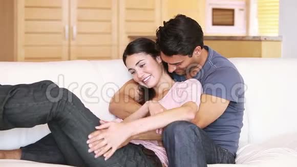 年轻夫妇拥抱在沙发上视频的预览图