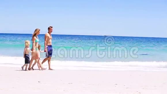 微笑的一家人走在沙滩上视频的预览图