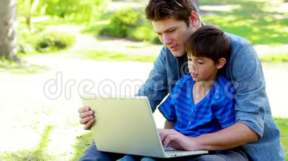 儿子和他父亲用笔记本电脑视频的预览图