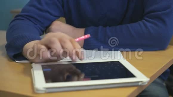 坐在书桌前的学生在笔记本上写字视频的预览图