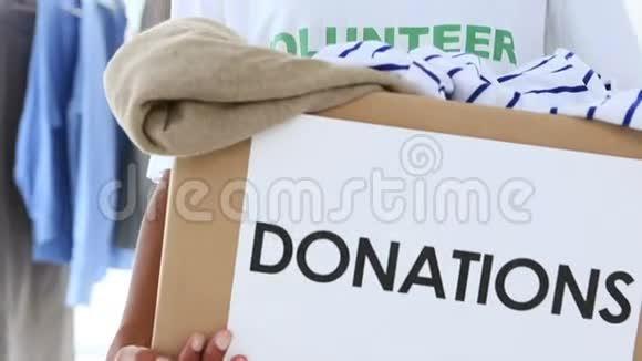 一个漂亮的志愿者拿着一个捐衣箱视频的预览图