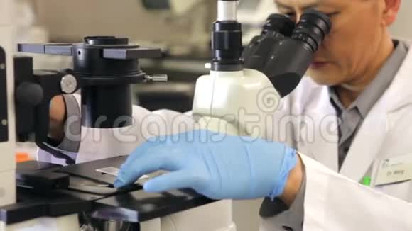 实验室使用显微镜的男性科学家视频的预览图