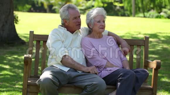 退休夫妇坐在长凳上视频的预览图