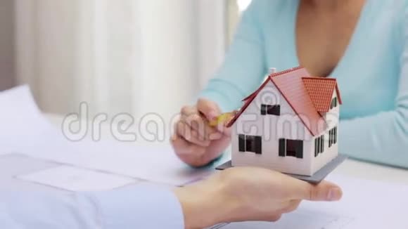 女人和建筑师讨论房子的模型视频的预览图