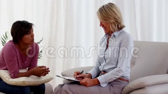 坐在沙发上跟治疗师说话的女人视频的预览图