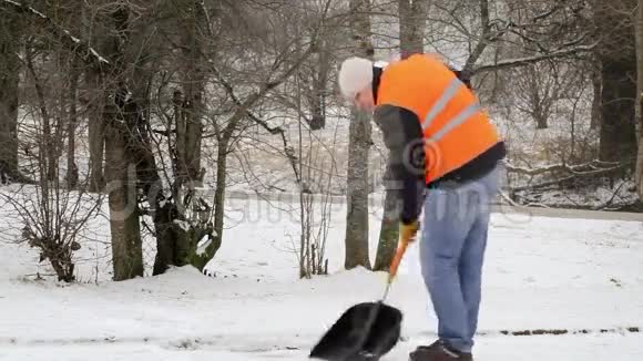 冬天在人行道上铲雪的工人视频的预览图