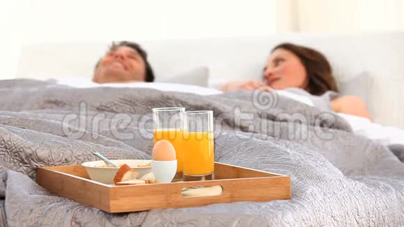 一对在床上吃早餐的夫妇视频的预览图