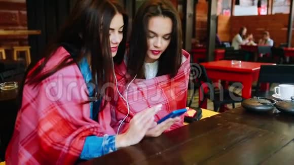 两个女孩用智能手机听音乐视频的预览图