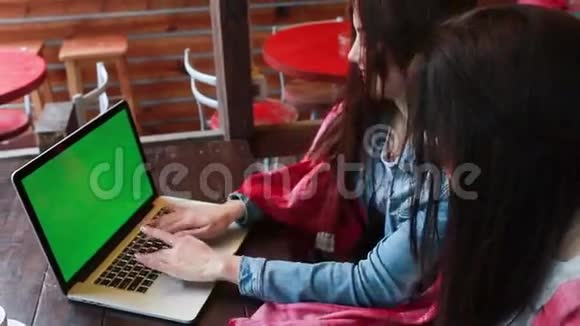 两个女孩在笔记本电脑里看东西视频的预览图