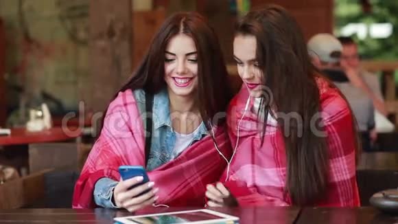 两个女孩用智能手机听音乐视频的预览图
