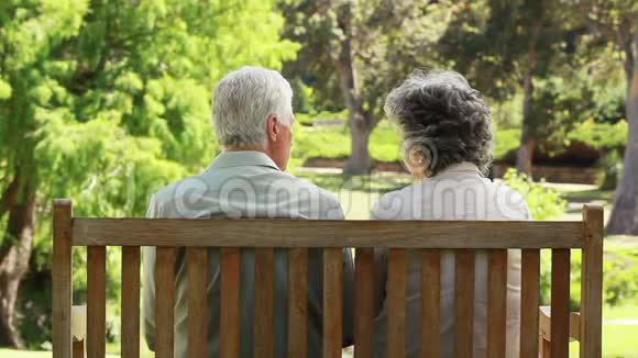 快乐的一对夫妻坐在长凳上聊天视频的预览图