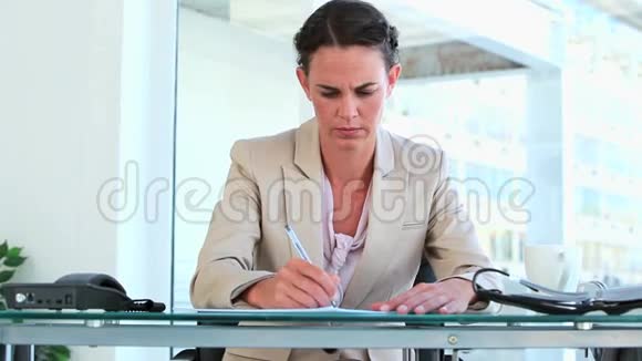 穿西装的女人坐在办公桌前视频的预览图