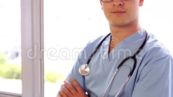 年轻的外科医生双臂交叉地微笑着视频的预览图