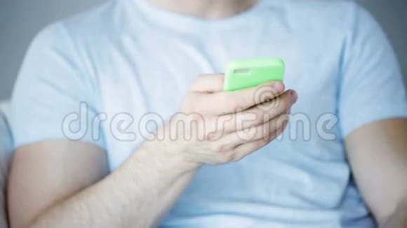 在家里用智能手机发短信的男人视频的预览图