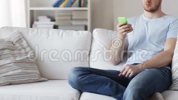 在家里用智能手机发短信的男人视频的预览图