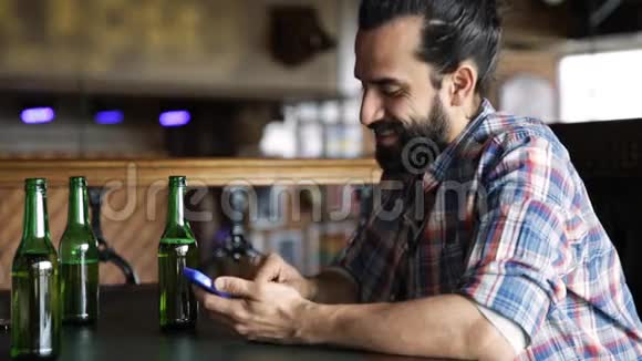 有智能手机的男人在酒吧或酒吧喝啤酒视频的预览图
