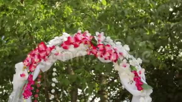 草地上有鲜花的婚礼拱门视频的预览图