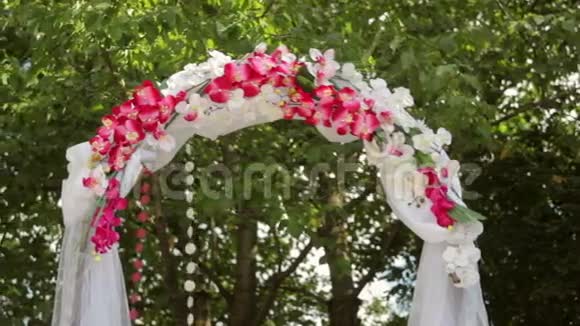 草地上有鲜花的婚礼拱门视频的预览图