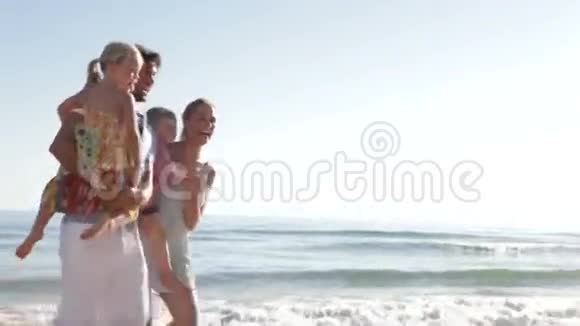 一家人沿着海滩海岸线跑步视频的预览图
