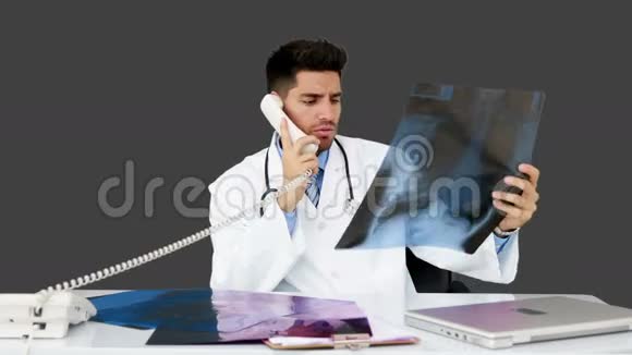 年轻的医生在他的办公桌前工作视频的预览图