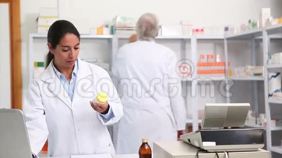 女药剂师微笑着拿着药盒视频的预览图