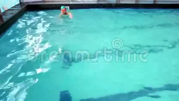 可爱的小男孩在游泳池里游泳视频的预览图