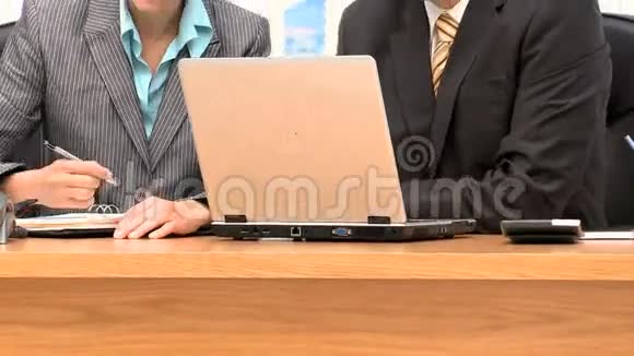 与笔记本电脑和记事本一起工作的商人视频的预览图