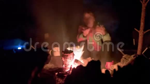 夜晚篝火周围的游客视频的预览图