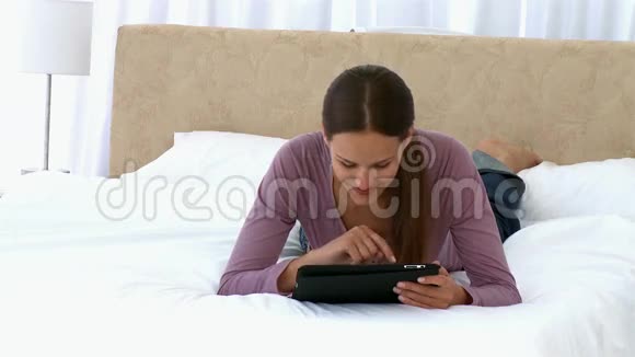 女人用平板电脑躺在床上视频的预览图