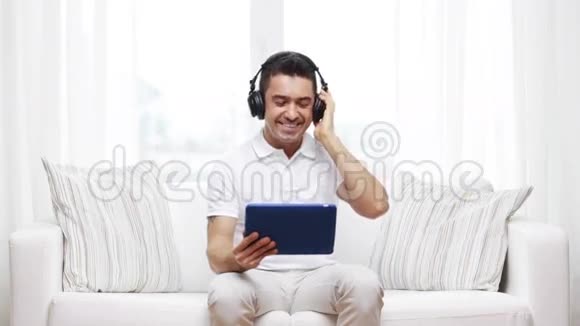 带着平板电脑和耳机的微笑男人视频的预览图