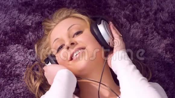 戴着耳机听音乐的漂亮年轻女人视频的预览图