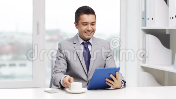微笑商人平板电脑喝咖啡视频的预览图