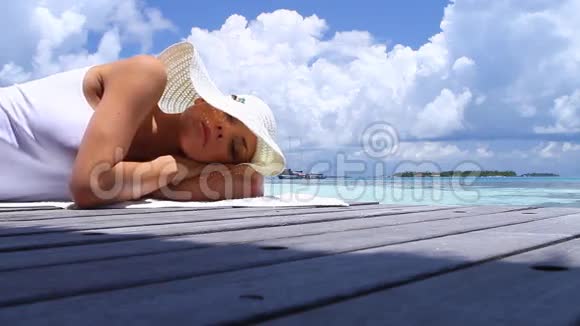 美丽的女人在水边休息视频的预览图
