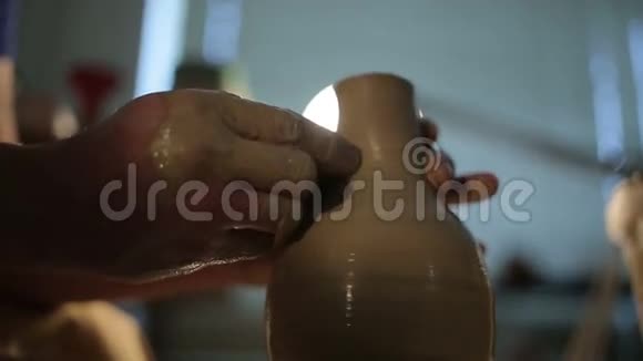 一只陶工的手在圆圈上制造一个土罐视频的预览图