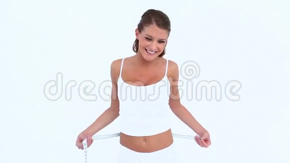 微笑的女人测量她的腰部视频的预览图