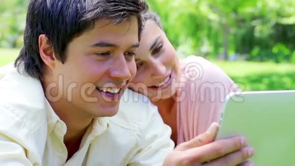 一对微笑的夫妇看着平板电脑视频的预览图
