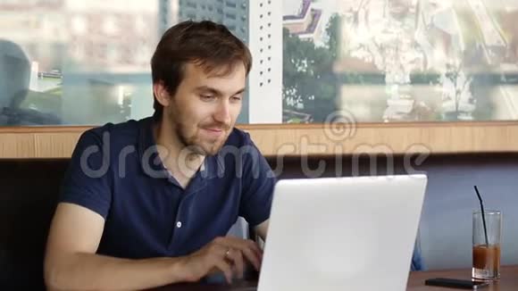 一个坐在咖啡馆里拿着笔记本电脑工作的人视频的预览图