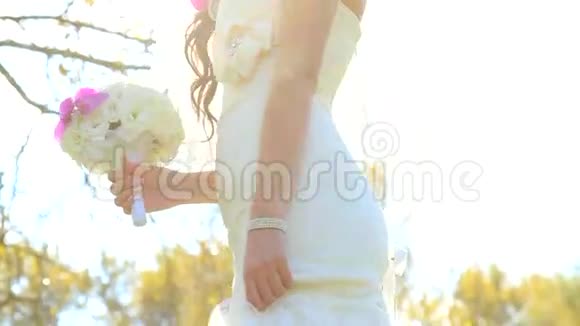 穿着白色婚纱的美丽新娘手中的婚礼花束视频的预览图
