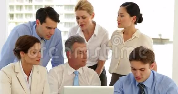微笑的商业团队在笔记本电脑前工作视频的预览图