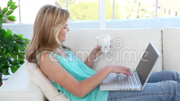 金发女人用她的笔记本电脑视频的预览图