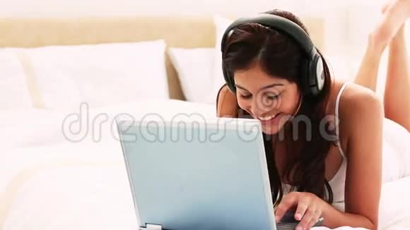 用笔记本电脑微笑的黑发女人视频的预览图