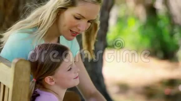 妈妈和女儿坐在长凳上视频的预览图