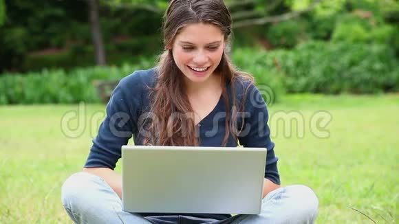 快乐的女人在她的笔记本电脑上打字视频的预览图