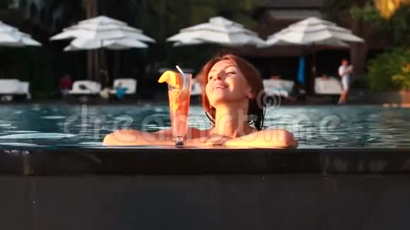 在游泳池里喝鸡尾酒的女人视频的预览图
