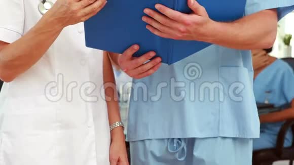 两名医生拿着剪贴板视频的预览图