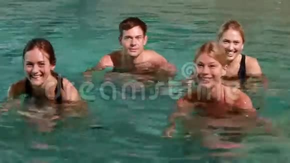 四个微笑的人在游泳池里做水上有氧运动视频的预览图