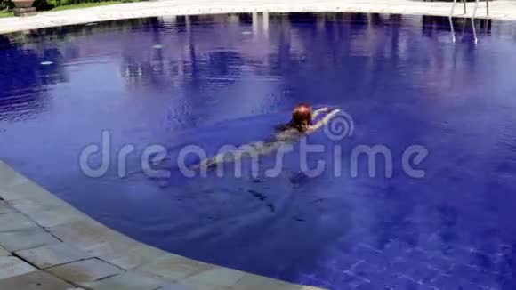 年轻漂亮的女人在游泳池里游泳视频的预览图