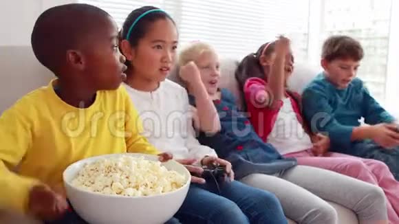 可爱的孩子在沙发上玩电子游戏视频的预览图