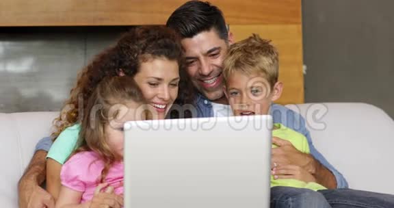 家长和孩子在沙发上使用笔记本电脑视频的预览图