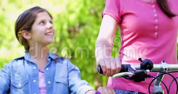 笑着母女俩一起骑自行车在公园里视频的预览图